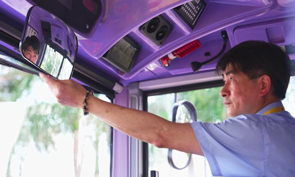 Bus captain adjusts the mirrors before driving